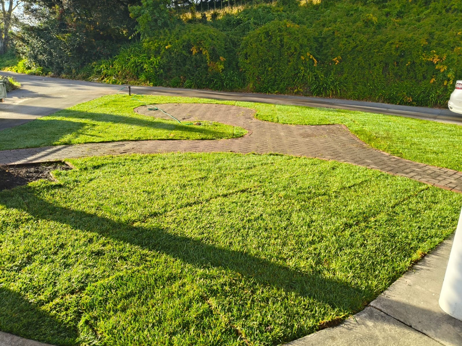 Finished green lawn beside the brick path with distant mountain views