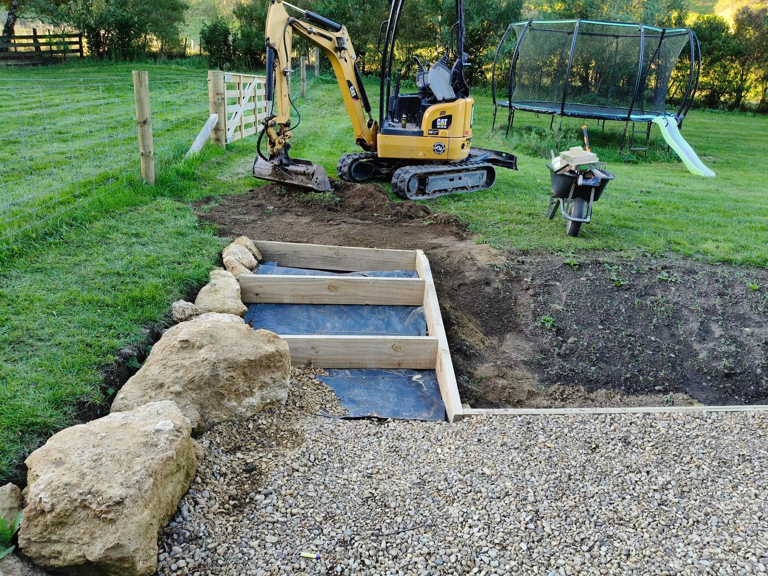 CAT excavator working on residential backyard steps and gravel path