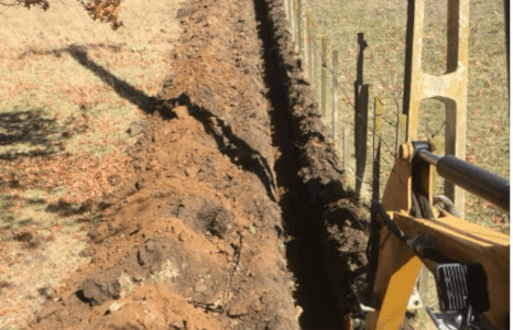 Service trench dug along a rural property